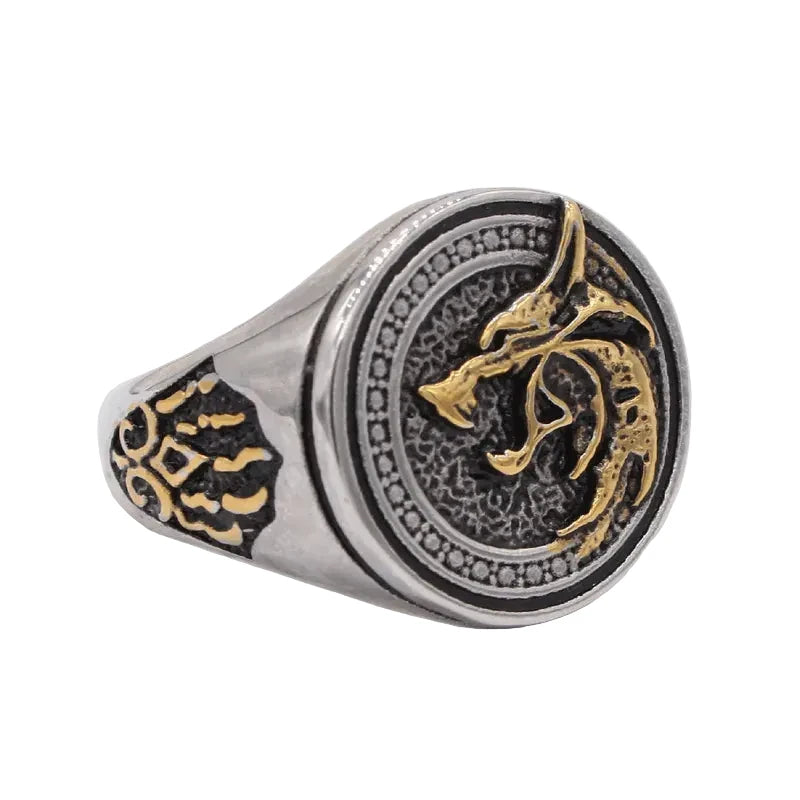 Silver and gold ring with intricate design on a white background